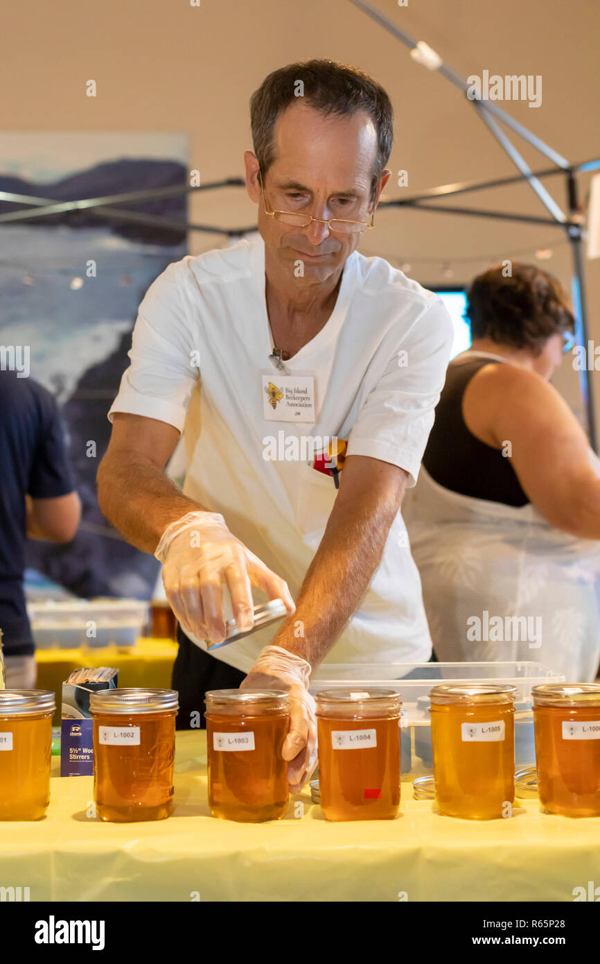 Hilo, Hawaii - ein Honig Geschmack Testen während der jährlichen Schwarze und Weiße Nacht. Die Leute wurden aufgefordert, ihren Favoriten unter den Honig zu stimmen. Schwarz und Whit Stockfoto