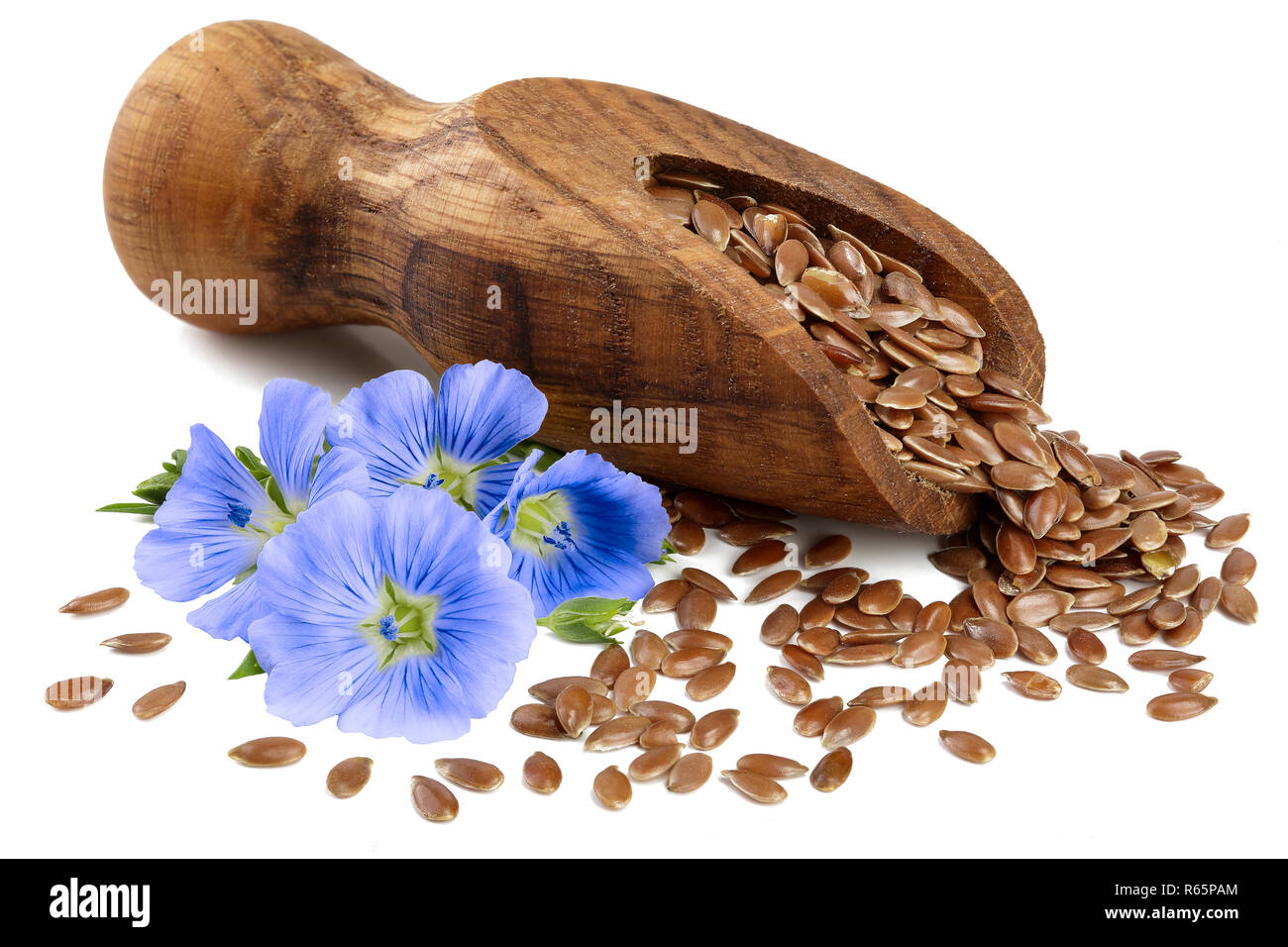 Leinsamen in Holz- Schaufel mit Blumen auf weißem Hintergrund Stockfoto