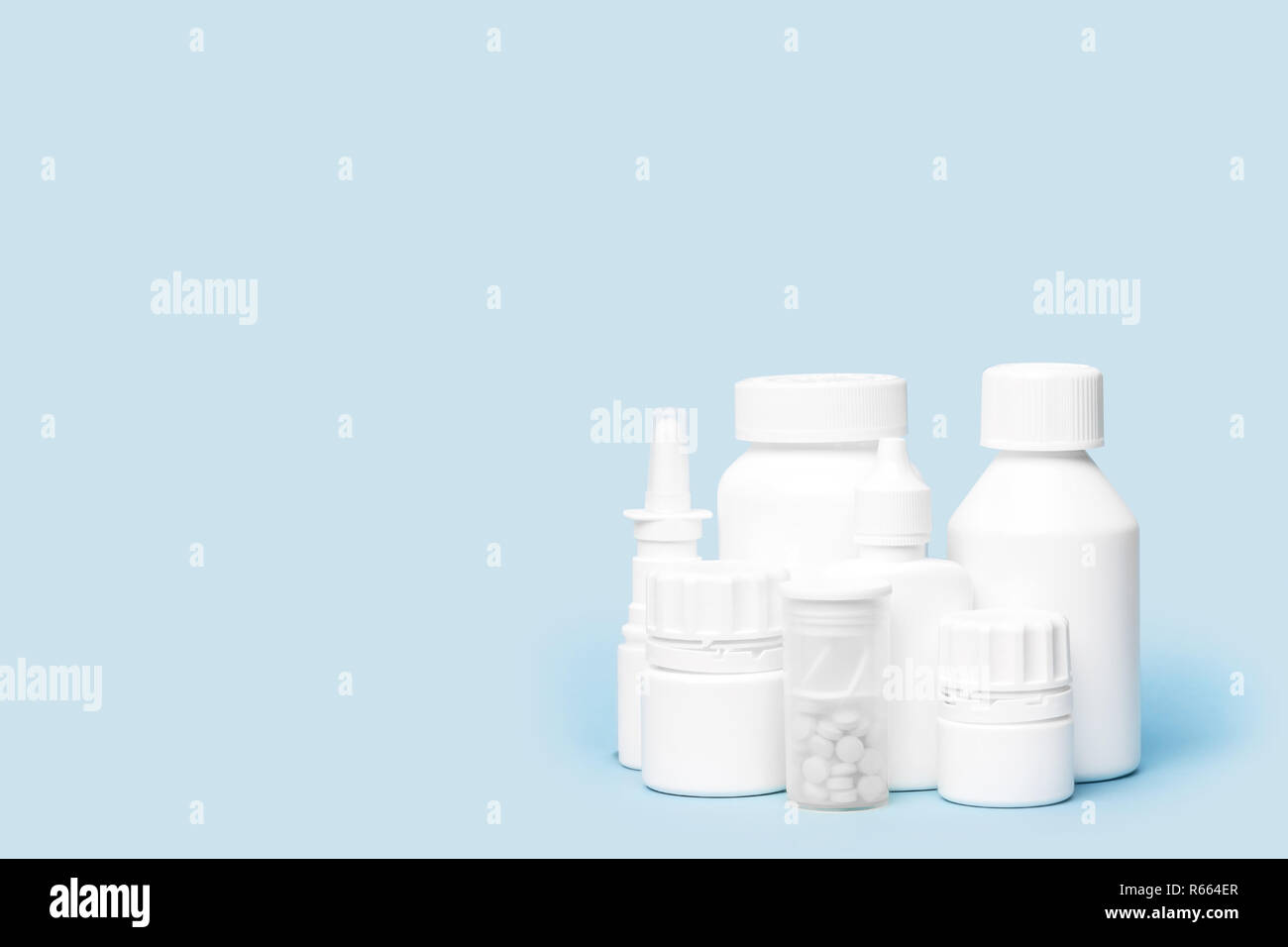 Mehrere sauberen, weißen medizinische Flaschen in der Ecke auf blauem Hintergrund shot mit Studio Light angeordnet Stockfoto