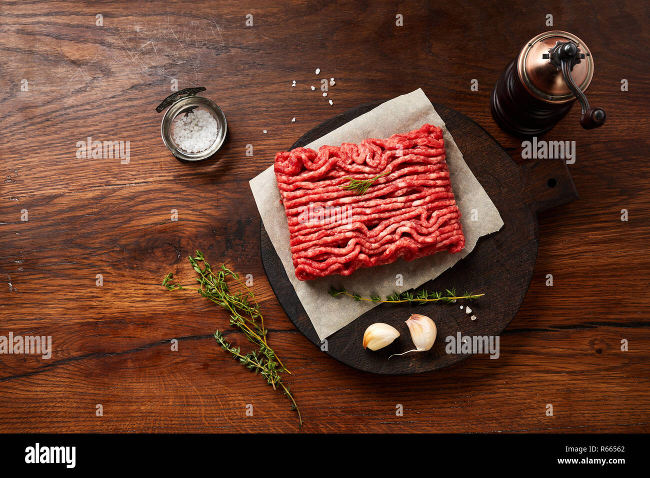 Hackfleisch Fleisch mit Salz, Knoblauch, Kräutern auf Holztisch. Ansicht von oben. Stockfoto