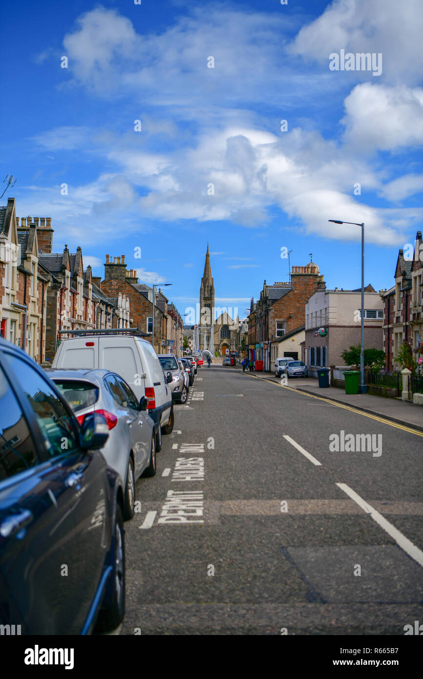 Von Inverness in Schottland Straße, im Hintergrund Turm der Kirche, Häuser und Hotels auf den Seiten Stockfoto