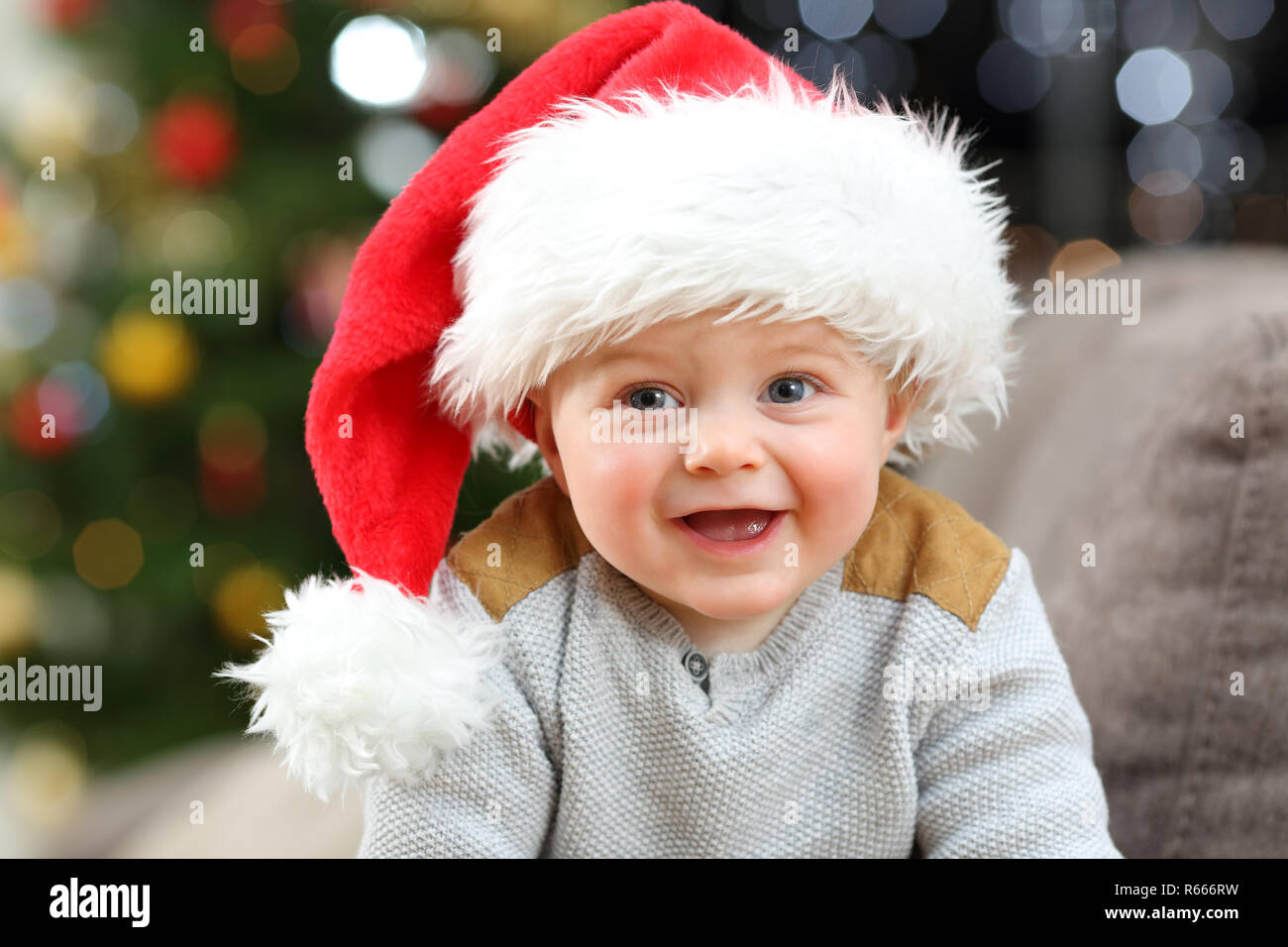 Baby Tragen santa hut Posing bei camera Suchen in Weihnachten Stockfoto