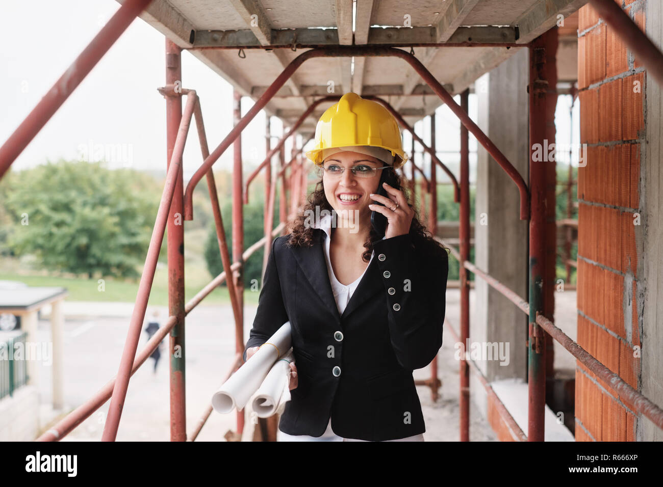 Ingenieurin Gespräch am Handy in Baustelle Stockfoto