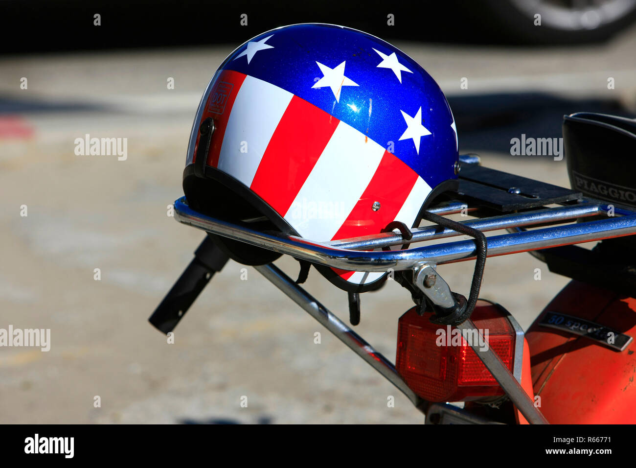 Patriotische Sternenbanner Sturzhelm ruht auf einem motorradhalter glitzert in der Sonne Kaliforniens Stockfoto