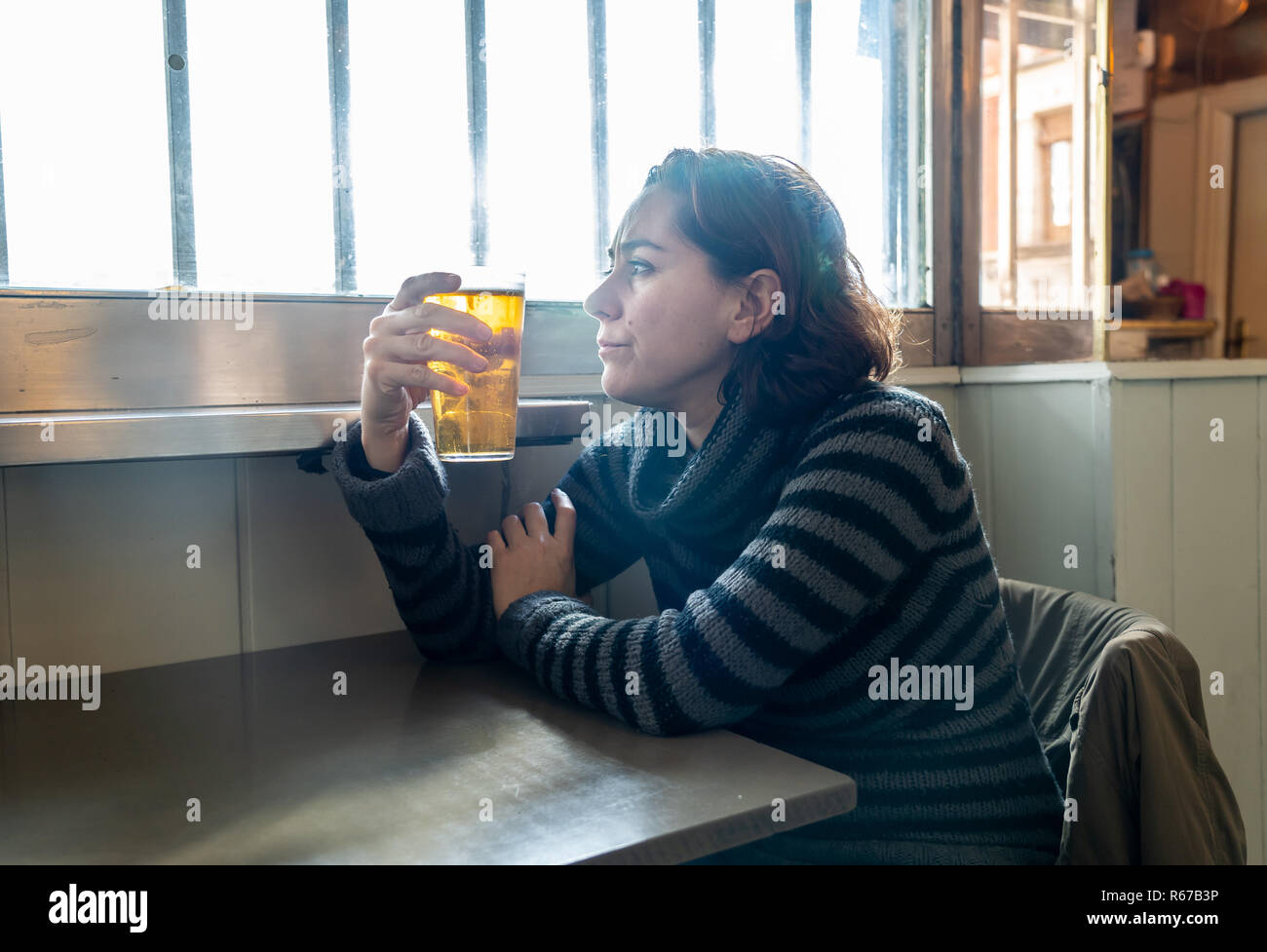 Porträt einer attraktiven Latein Frau trinkt Bier in einer Bar Pub deprimiert, unglücklich und einsam in Alkohol Missbrauch Depression und psychische Gesundheit Stockfoto