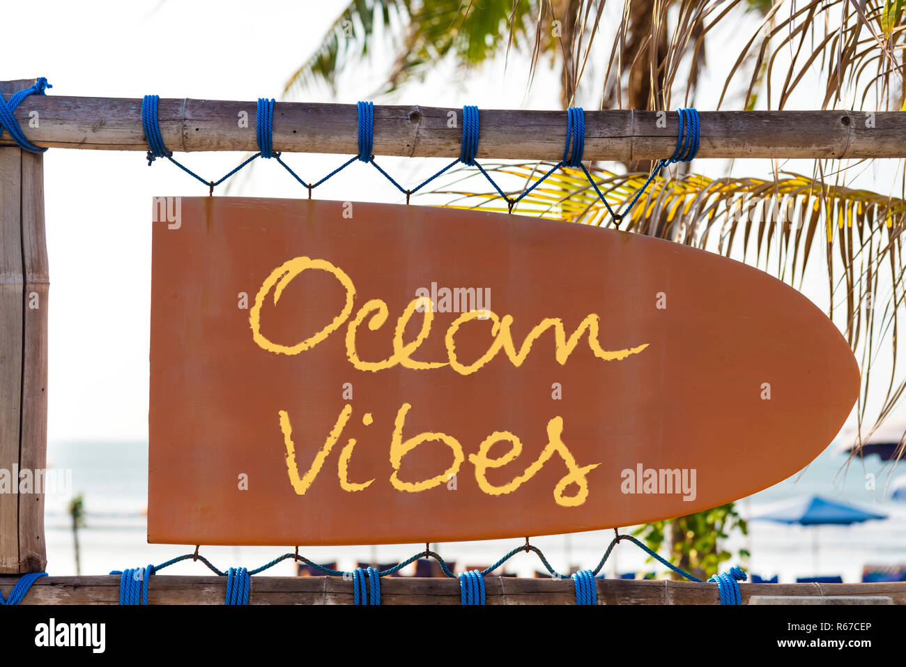 Orange vintage Schild in Form von Surfbrett mit Ozean Vibes text und Palmen im Hintergrund Stockfoto