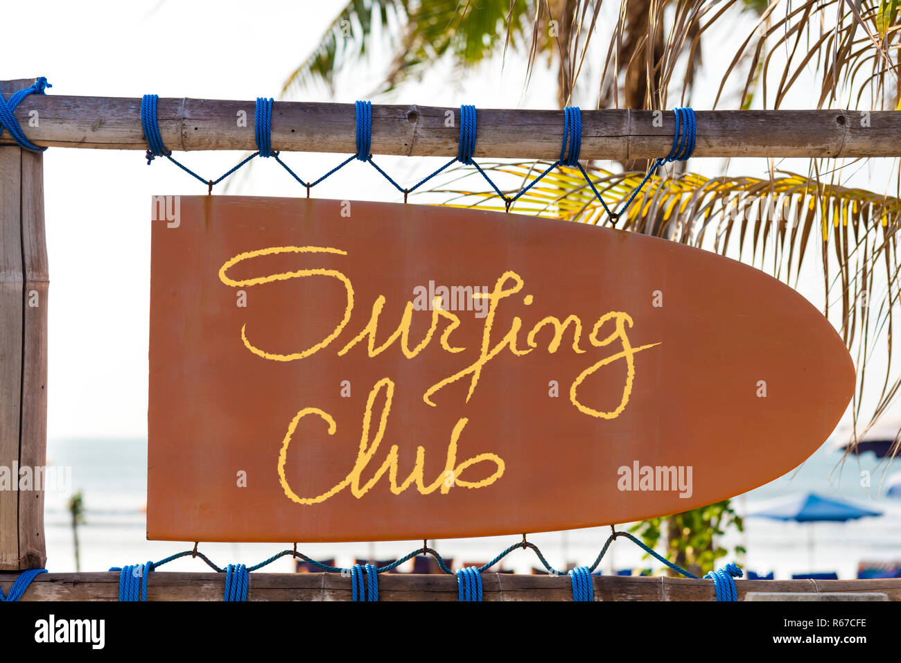 Orange vintage Schild in Form von Surfbrett mit Surfen Club text und Palmen im Hintergrund Stockfoto