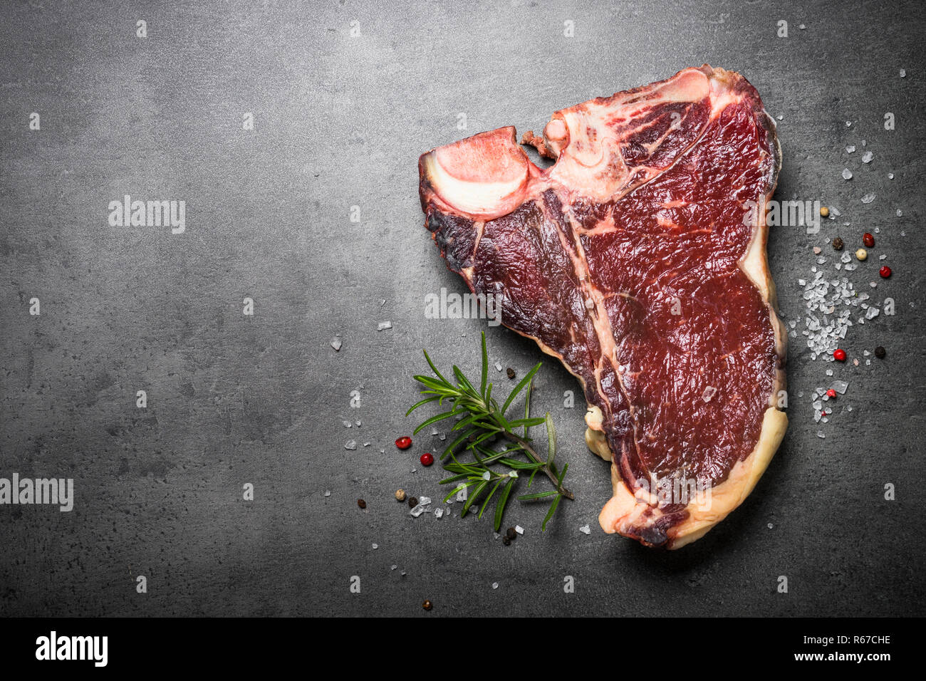 Trocken im Alter von Rindfleisch Steak T-Bone auf schwarzem Schiefer Hintergrund. Stockfoto