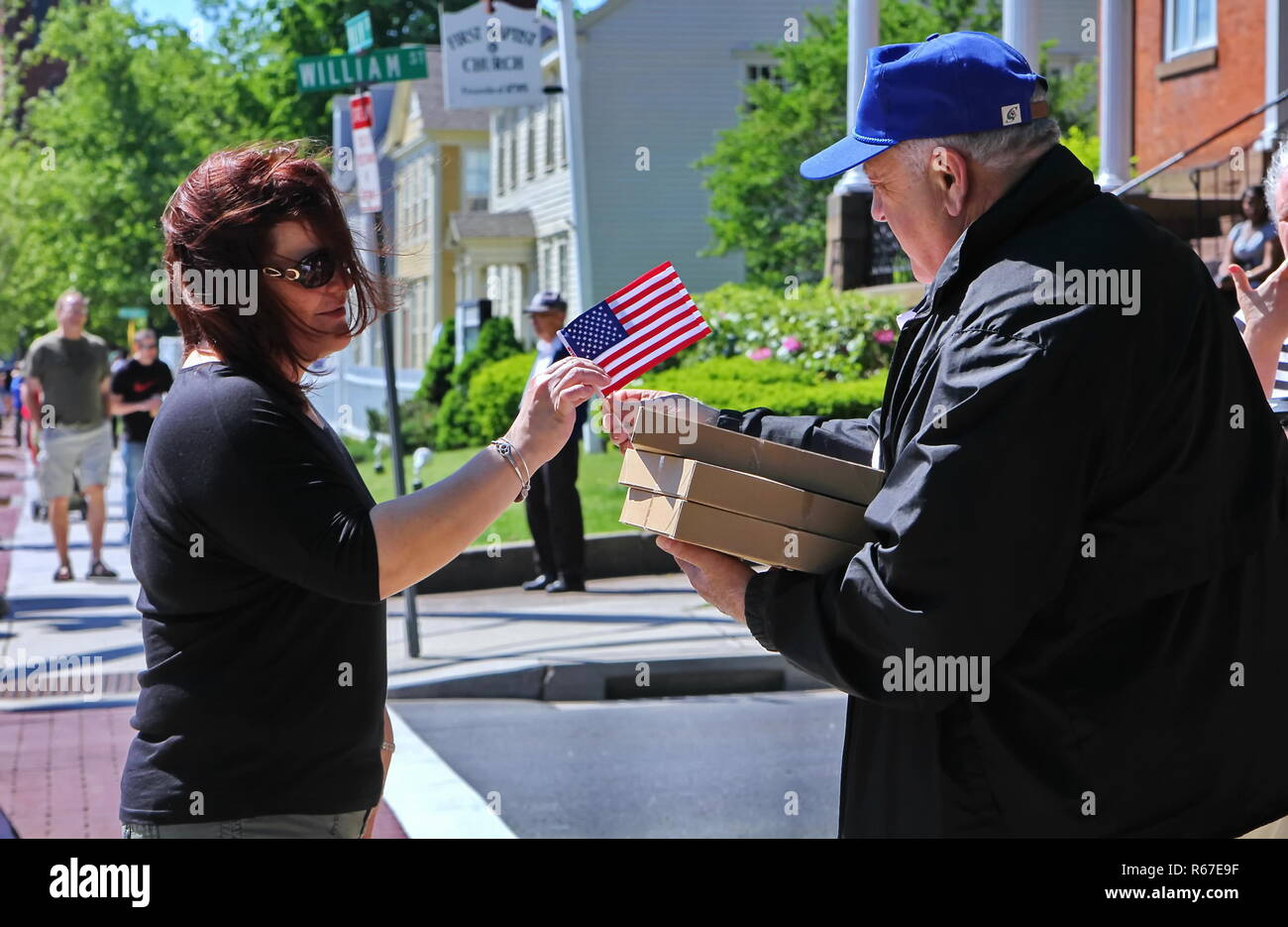 Middletown, CT USA. Mai 2018. Veteran aus Mini amerikanische Flaggen zu einer Frau während des Memorial Day Parade. Stockfoto