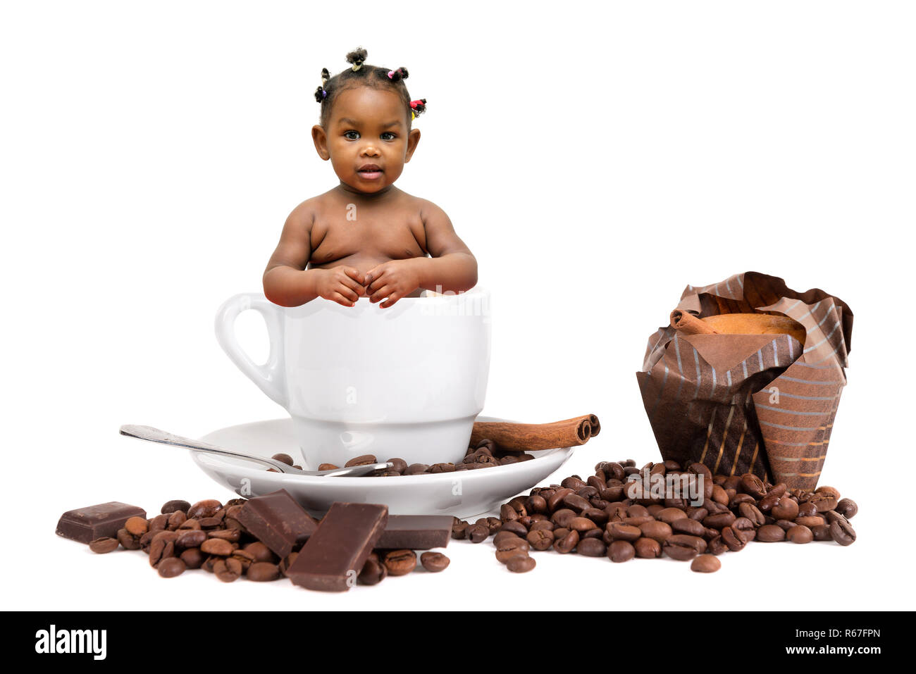 Baby in eine Tasse Kaffee mit Bohnen und Muffin Stockfoto
