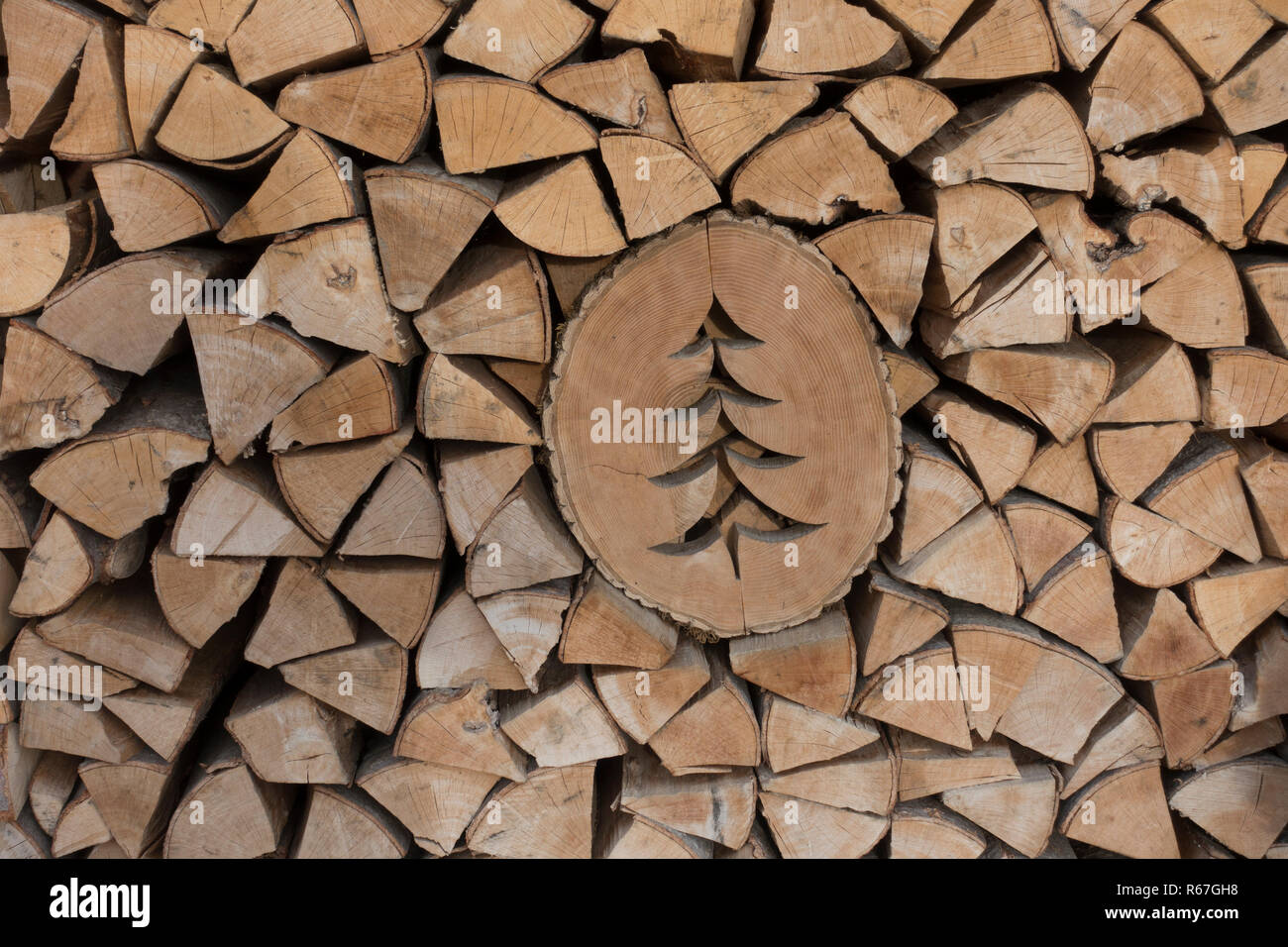 Gestapeltes Rundholz mit geschnitzten Tannenbaum Stockfoto