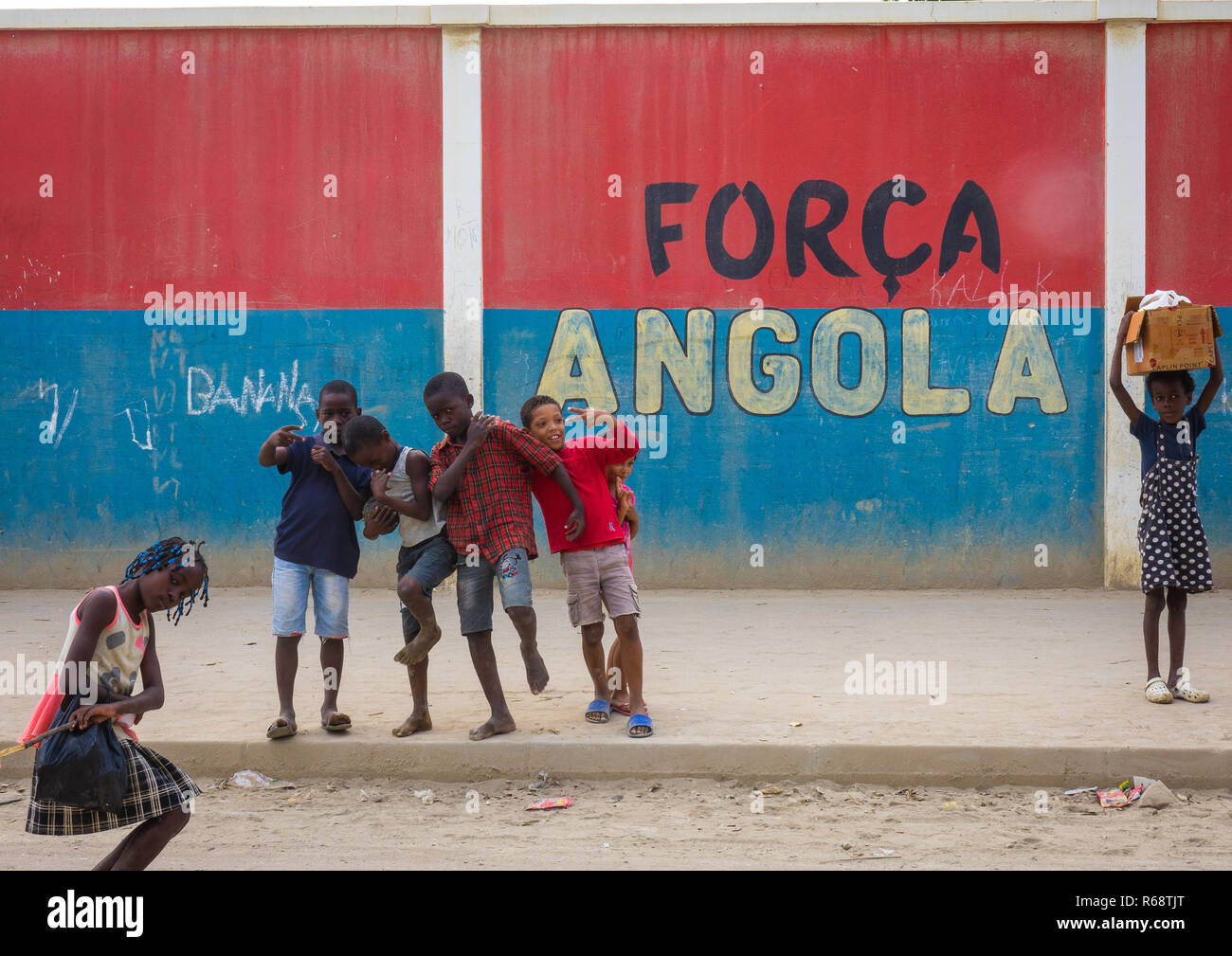 Kinder vor einer Wand mit einer nationalistischen Slogan, Provinz Benguela, Catumbela, Angola Stockfoto