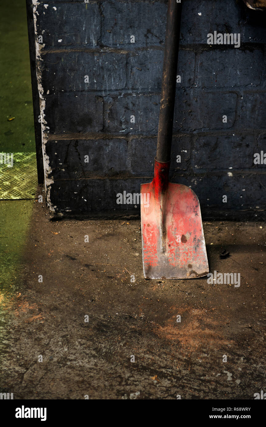 Eine rote Schaufel reduziert auf zwei Drittel der Kapazität. Stockfoto