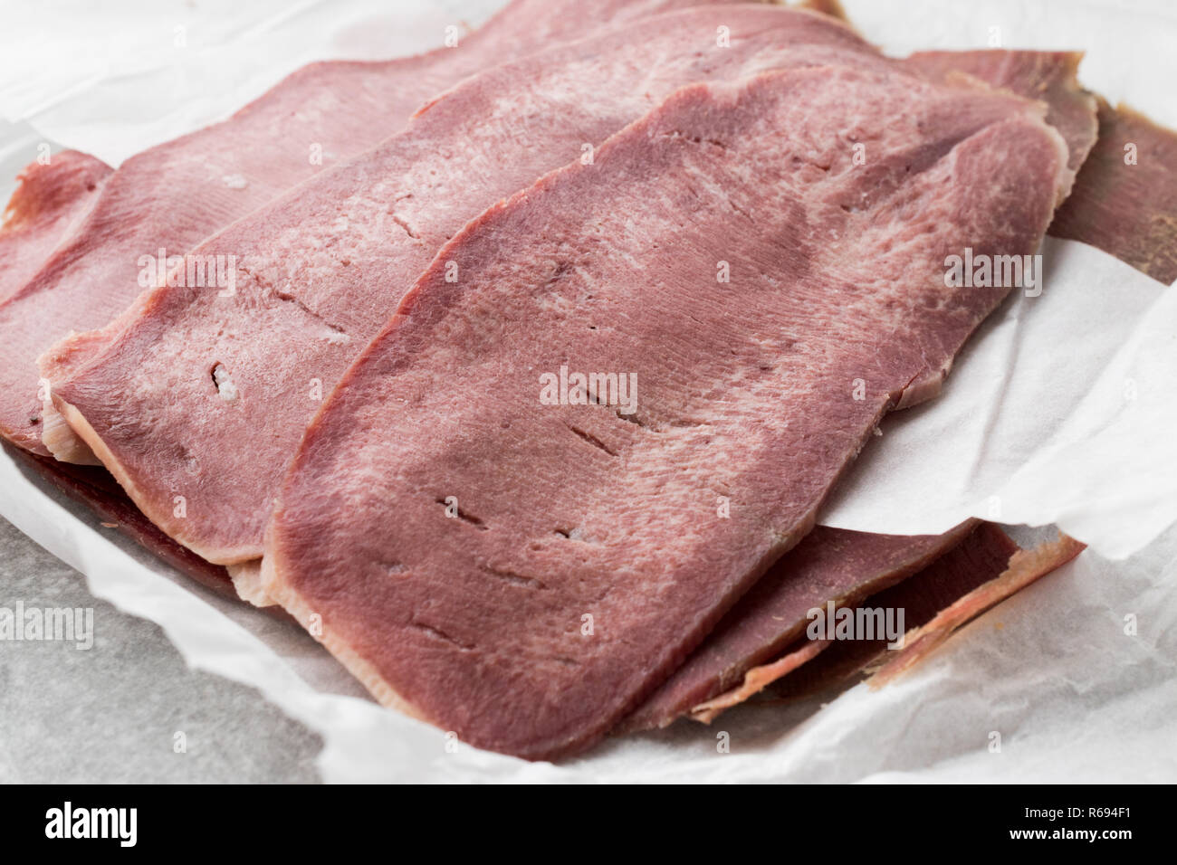 Geschnetzeltes Rindfleisch Zunge Schichten auf Papier. Bio geräuchertem Fleisch. Stockfoto