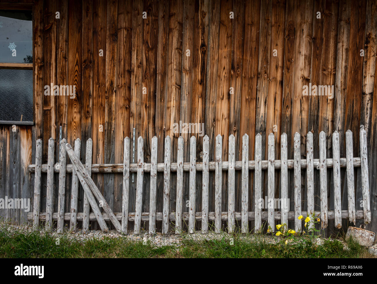 Alten hölzernen Zaun steht vor einem Schuppen Stockfoto