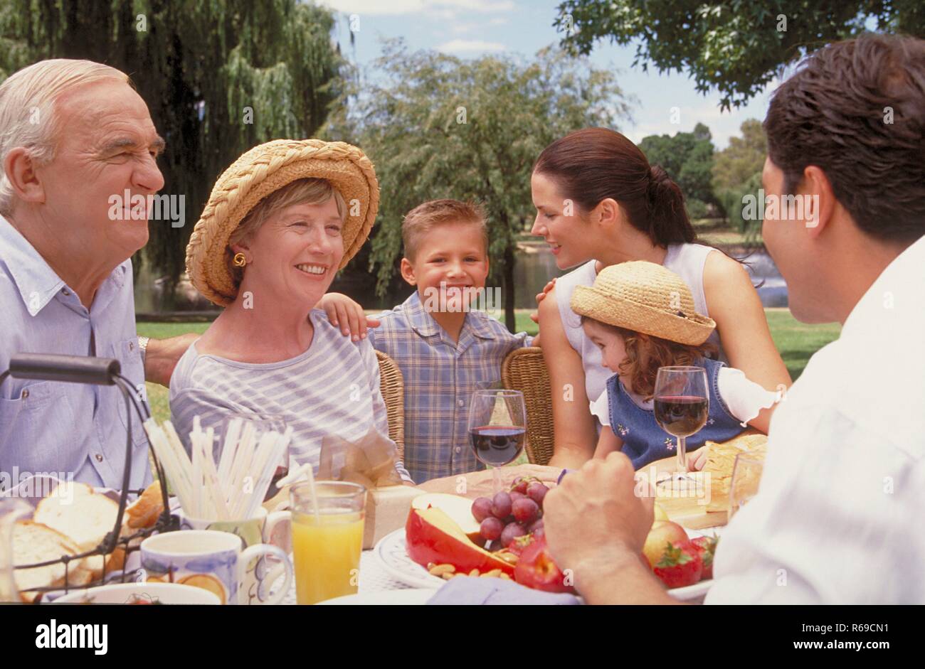 Parkszene, Porträt, 3 Generationen einer Familie geniessen einen Sommertag im Grünen bei einem Picknick Stockfoto