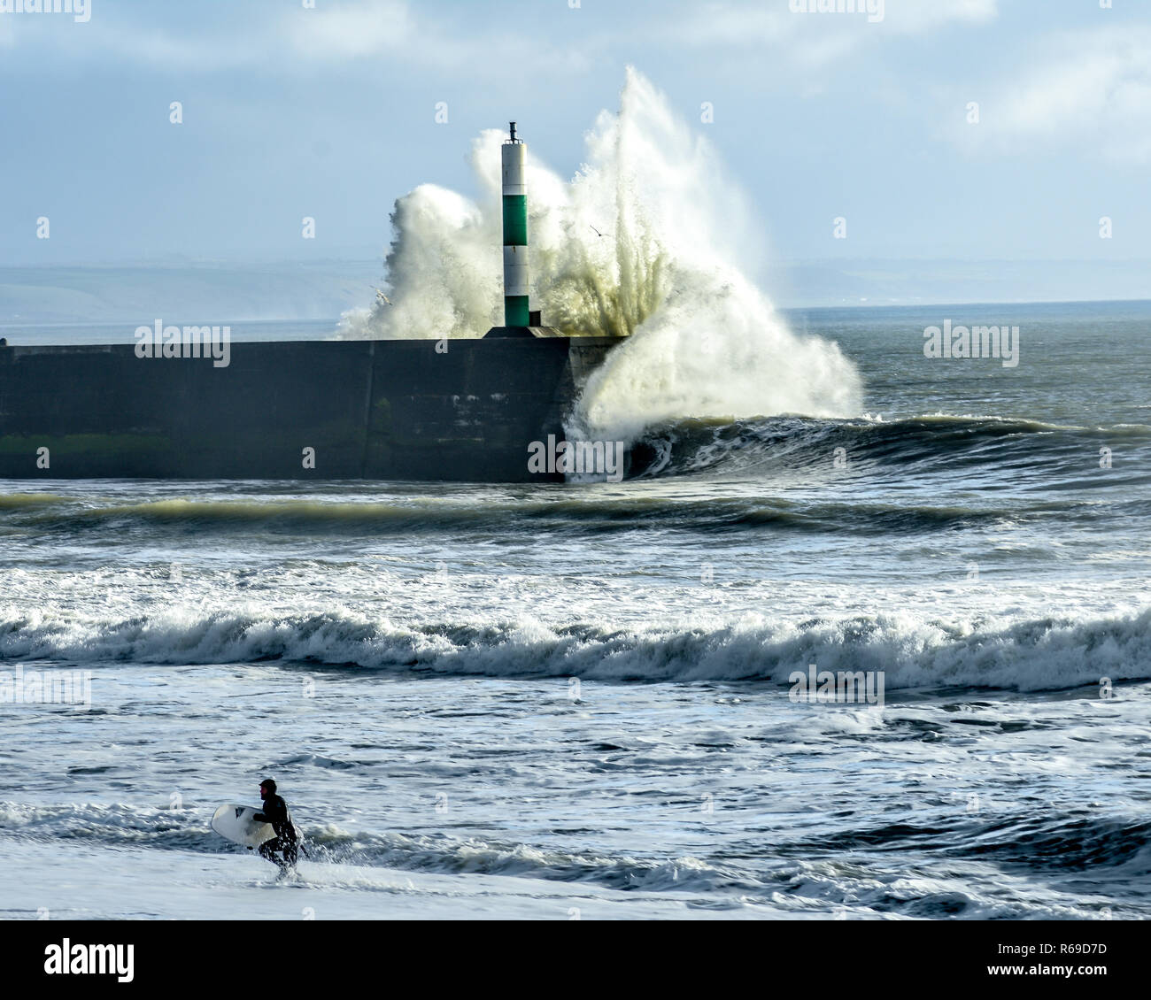 Surfer beenden Meer mit großen Wellen in Aberystwyth Stockfoto