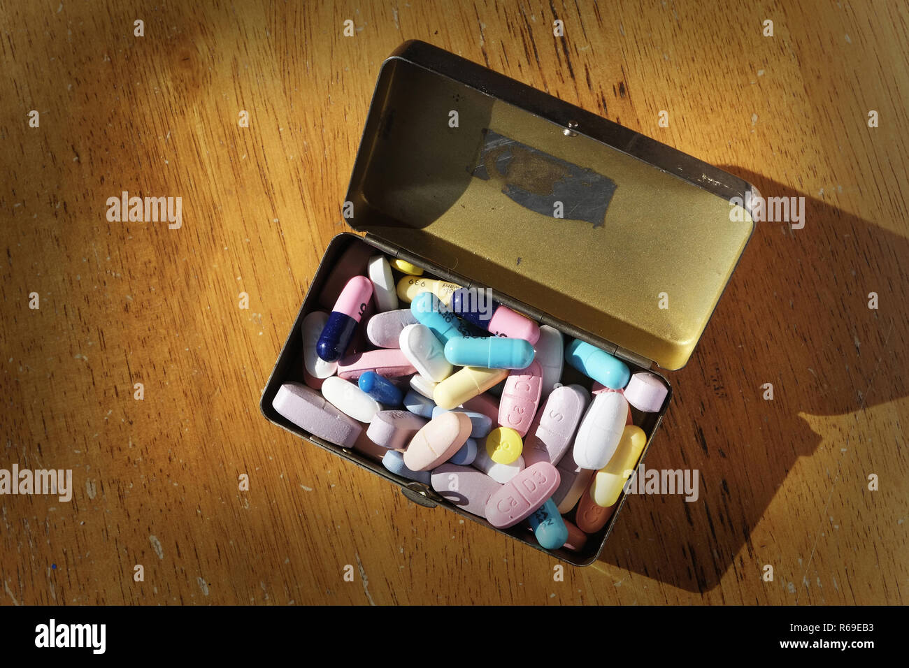 Mit mehreren farbigen Pillen in einem Metallbehälter gezeigt. Stockfoto