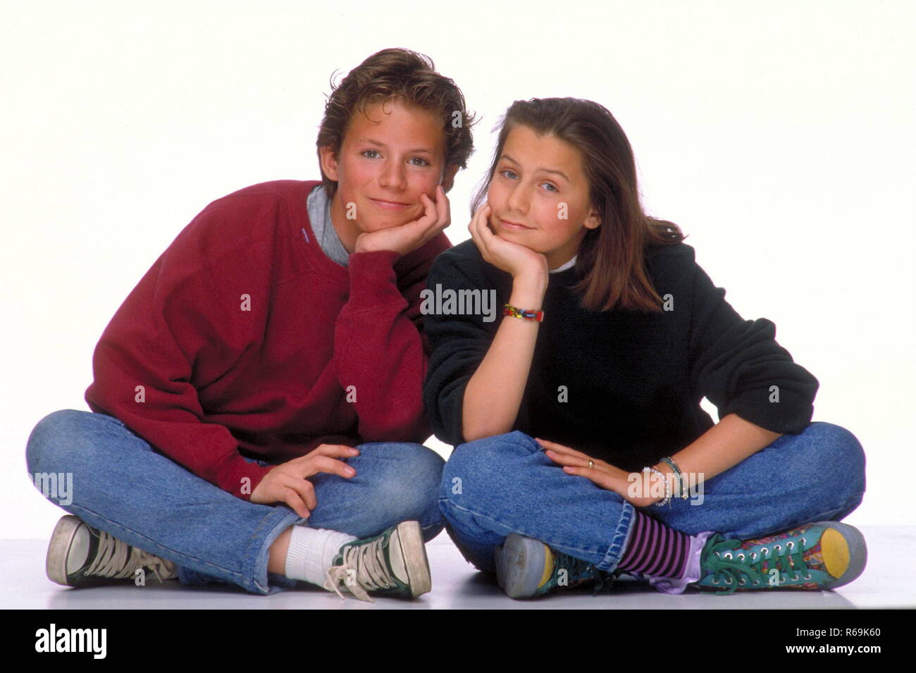 Porträt, Bruder und Schweaster in Jeans, 14 - 16 Jahre, Artikel im Schneidersitz auf dem Boden, den Kopf in den Ellenbogen gestuetzt Stockfoto
