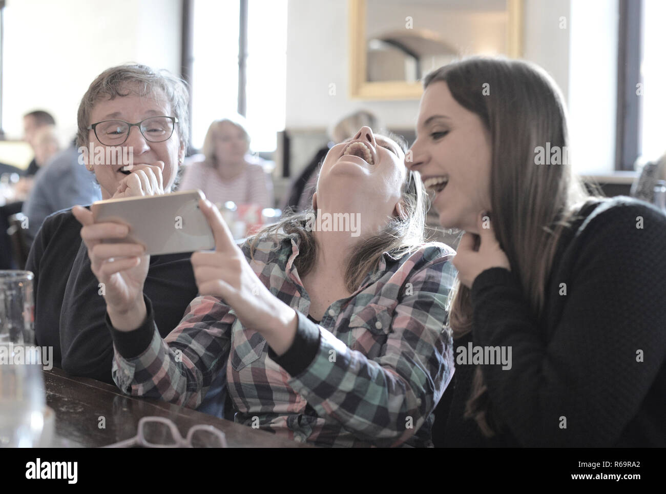 Junge Frauen und ältere Frauen, Smartphone, Lachen, Porträt, Café, Stuttgart, Baden-Württemberg, Deutschland Stockfoto