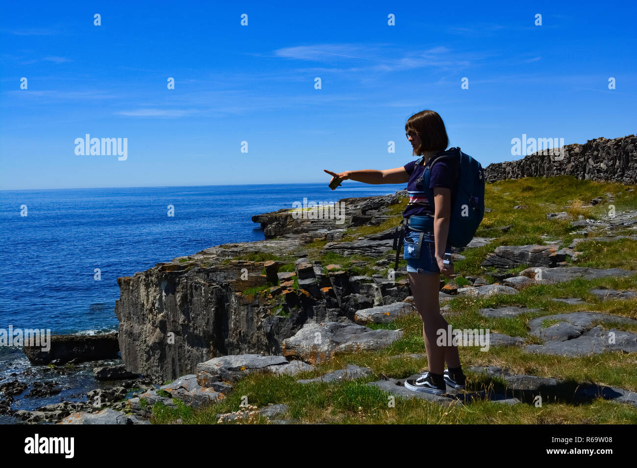 Reisende am Meer auf Felsen suchen. Stockfoto