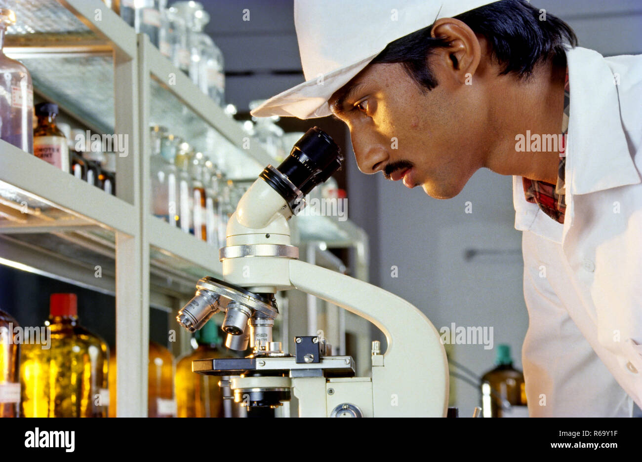 Mann schaut durch das Mikroskop im Labor, Indien, Asien Stockfoto