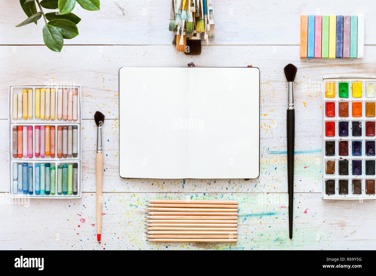 Kreative Schreibtisch für Selbstdarstellung, Pinsel, paintbox mit Wasserfarben, Buntstifte, Bleistifte und Notebook Papier auf weißem Hintergrund Holz, Arti Stockfoto