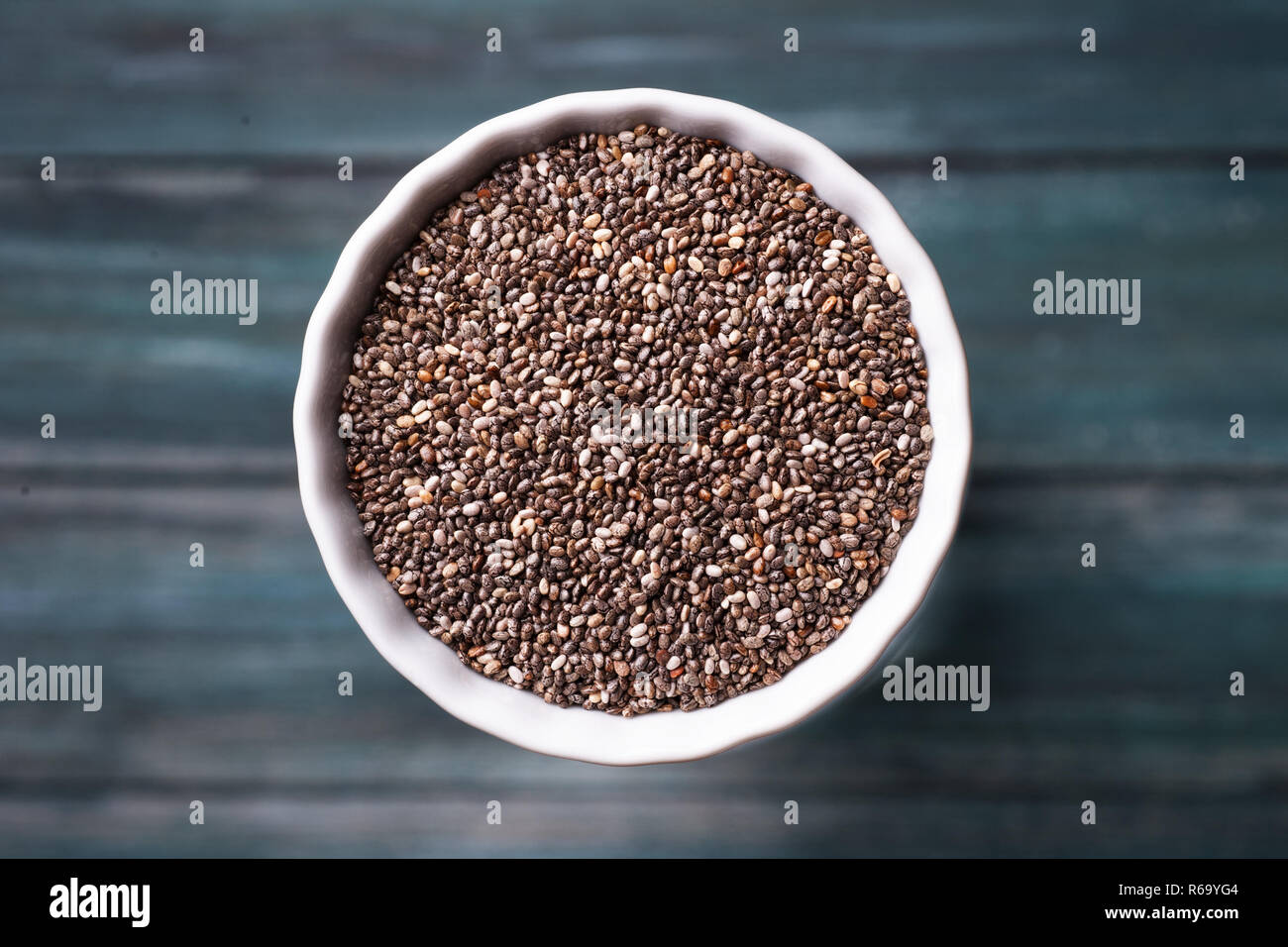 Quinoa Korn in eine Schüssel auf dem grünen Holz- Hintergrund. Stockfoto