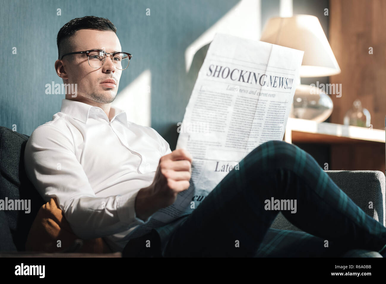 Jungen gutaussehenden Mann Brille lesen Schockierende Neuigkeiten Stockfoto