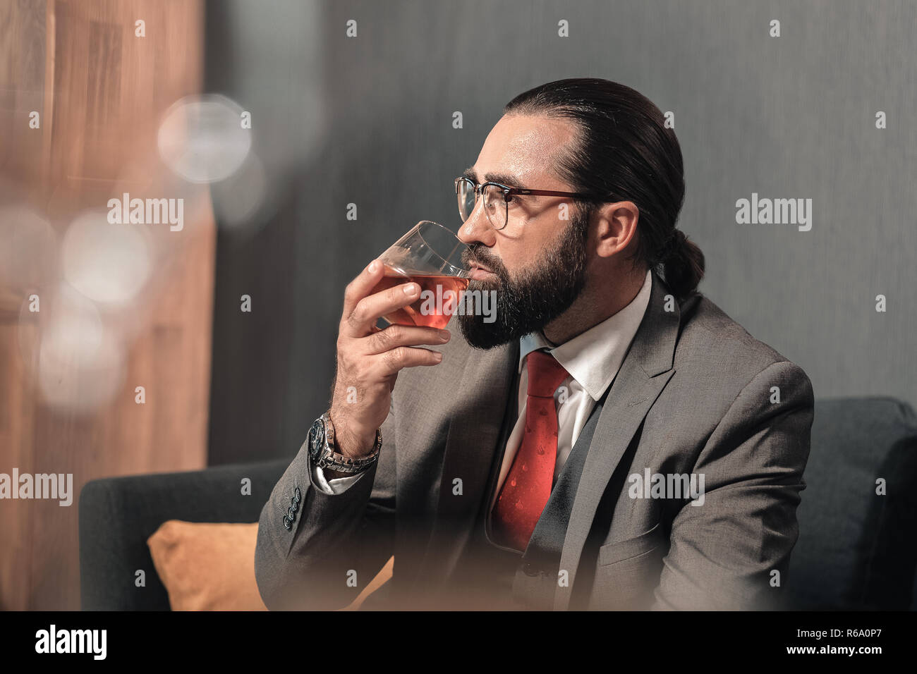 Erfolgreicher Mann tragende nette Hand watch Holding Glas Whisky Stockfoto