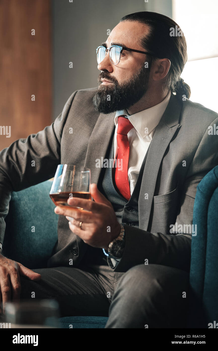 Unternehmer tragen rote Krawatte trinken Glas Whisky Stockfoto
