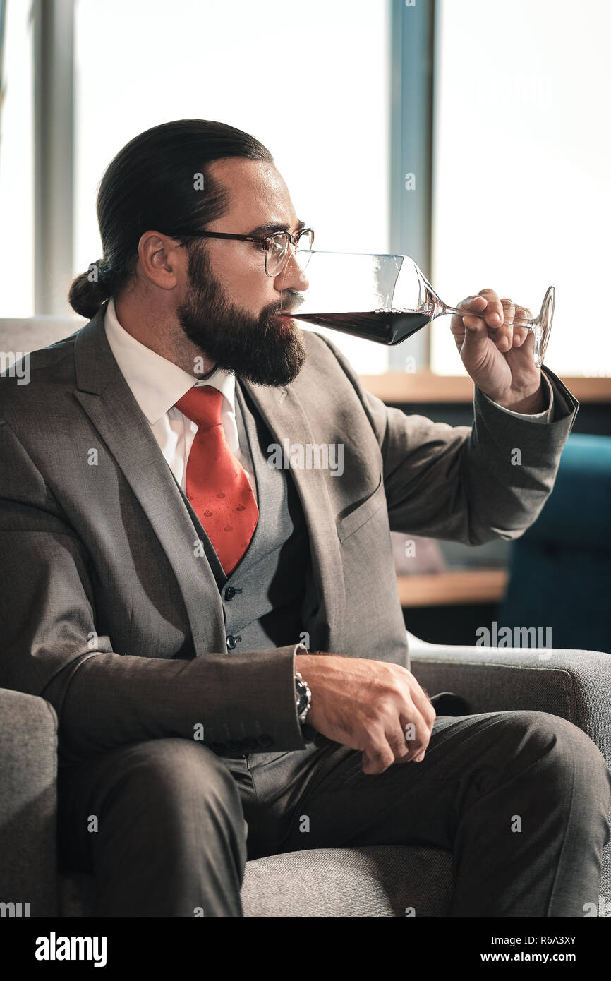 Erfahrenen Rechtsanwalt genießen Sie den Geschmack von Rotwein nach dem Arbeitstag Stockfoto
