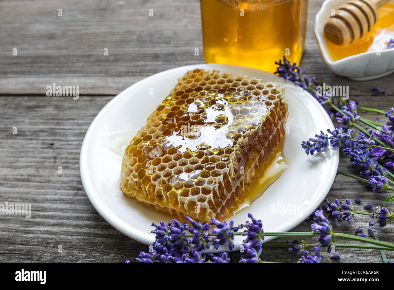 Honig mit Lavendelblüten und Waben auf rustikalen Holztisch. Gesundes essen. Nach oben Schließen Stockfoto