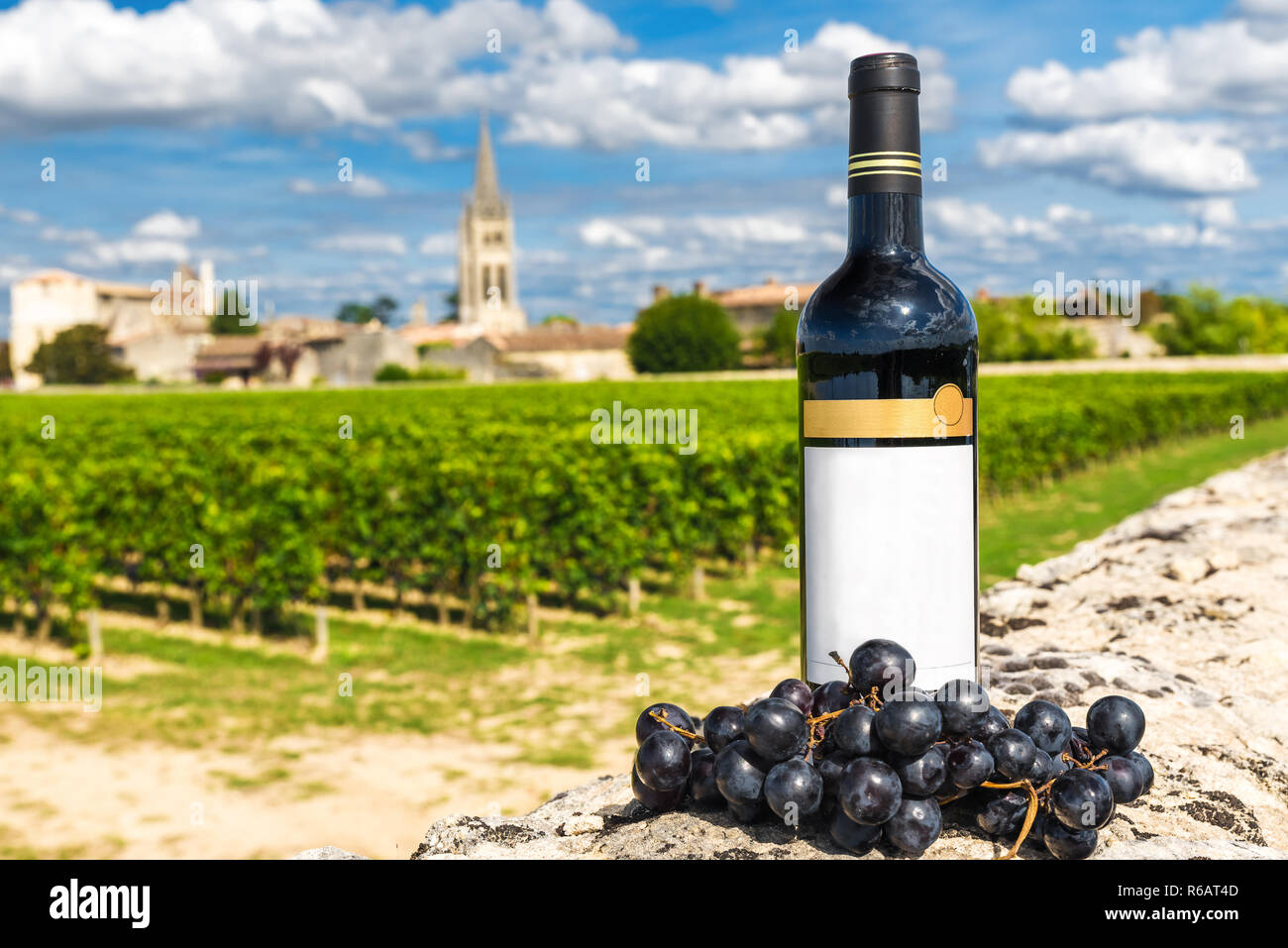 Flasche Rotwein vor dem Hintergrund der Weinberge von Saint Emilion, Bordeaux, Frankreich an einem sonnigen Tag Stockfoto