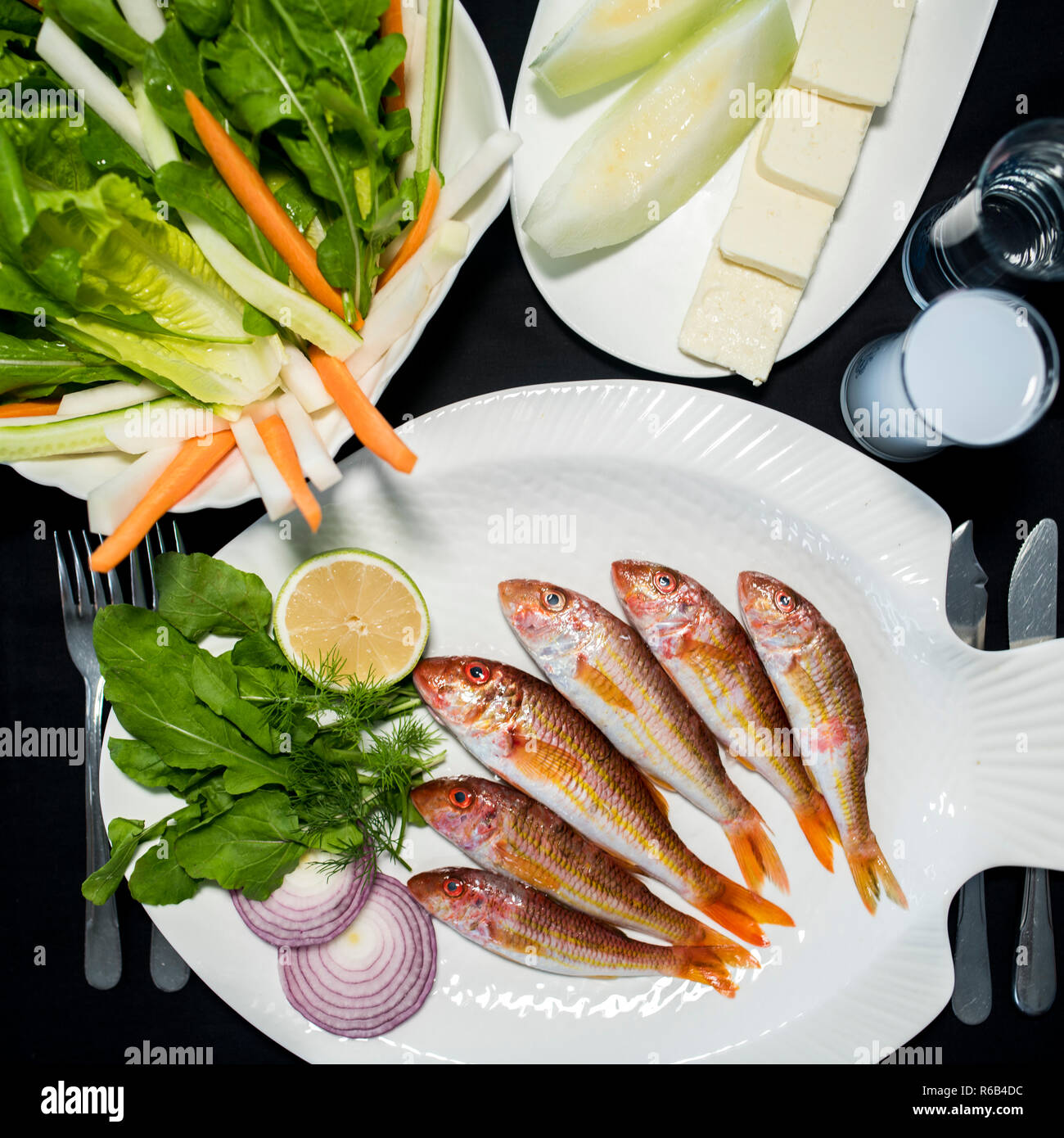 Frische rote Meeräsche Fische mit grünem Salat, Feta Käse, Melone und Türkische alkoholisches Getränk Raki Stockfoto