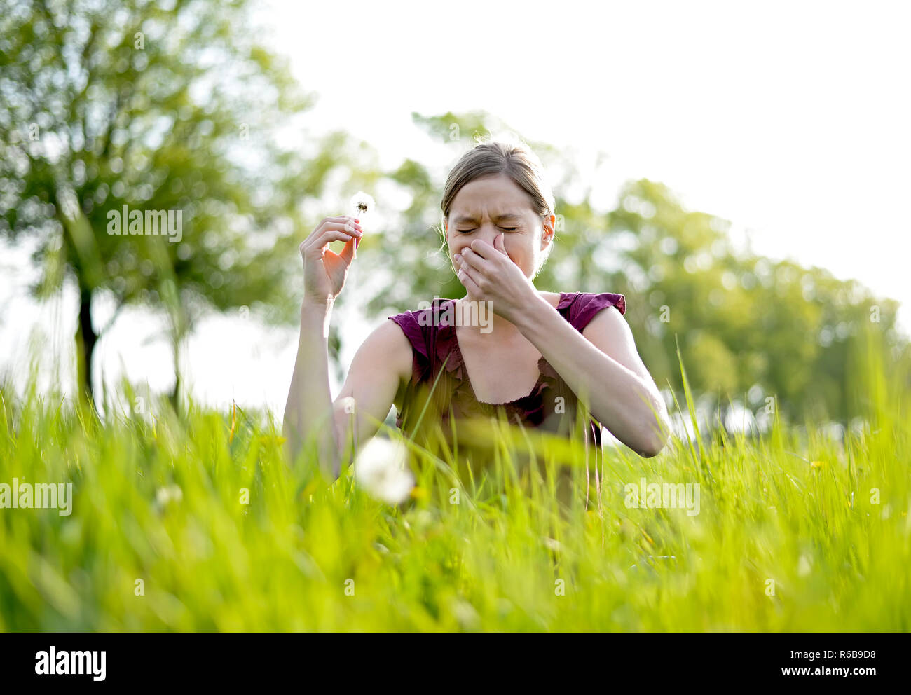 Junge Frau niest Stockfoto