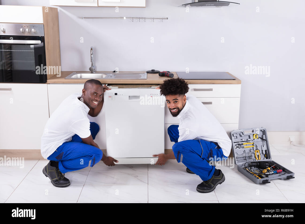Zwei praktische Männer zur Festsetzung der Geschirrspüler in der Küche Stockfoto