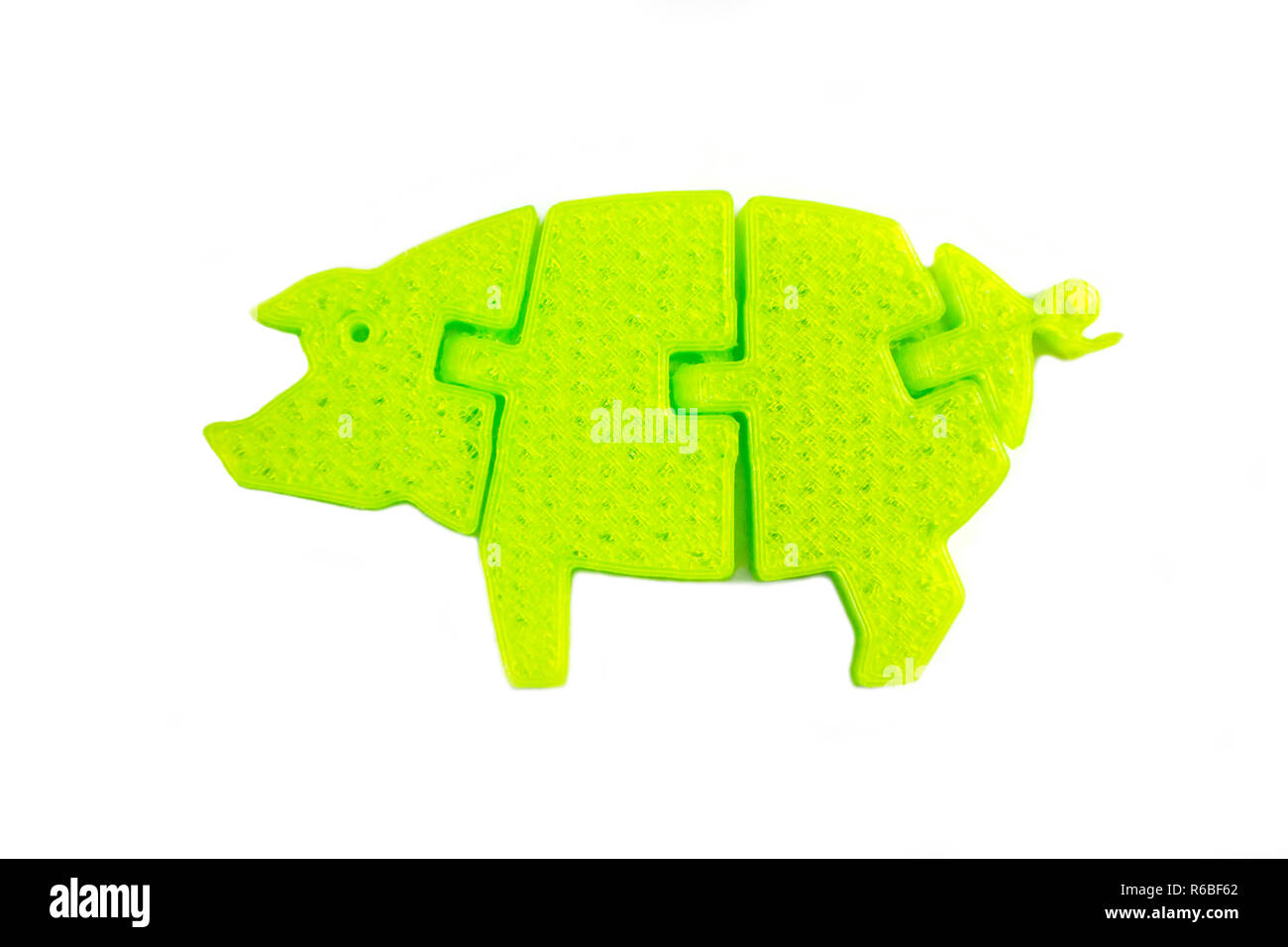 Helles Licht grünes Objekt in Form von Schwein Spielzeug auf 3d Drucker auf weißem Hintergrund gedruckt. Fused Deposition Modeling, FDM. Konzept moderne progressive Additiv Technologie für 3D-Druck. Stockfoto