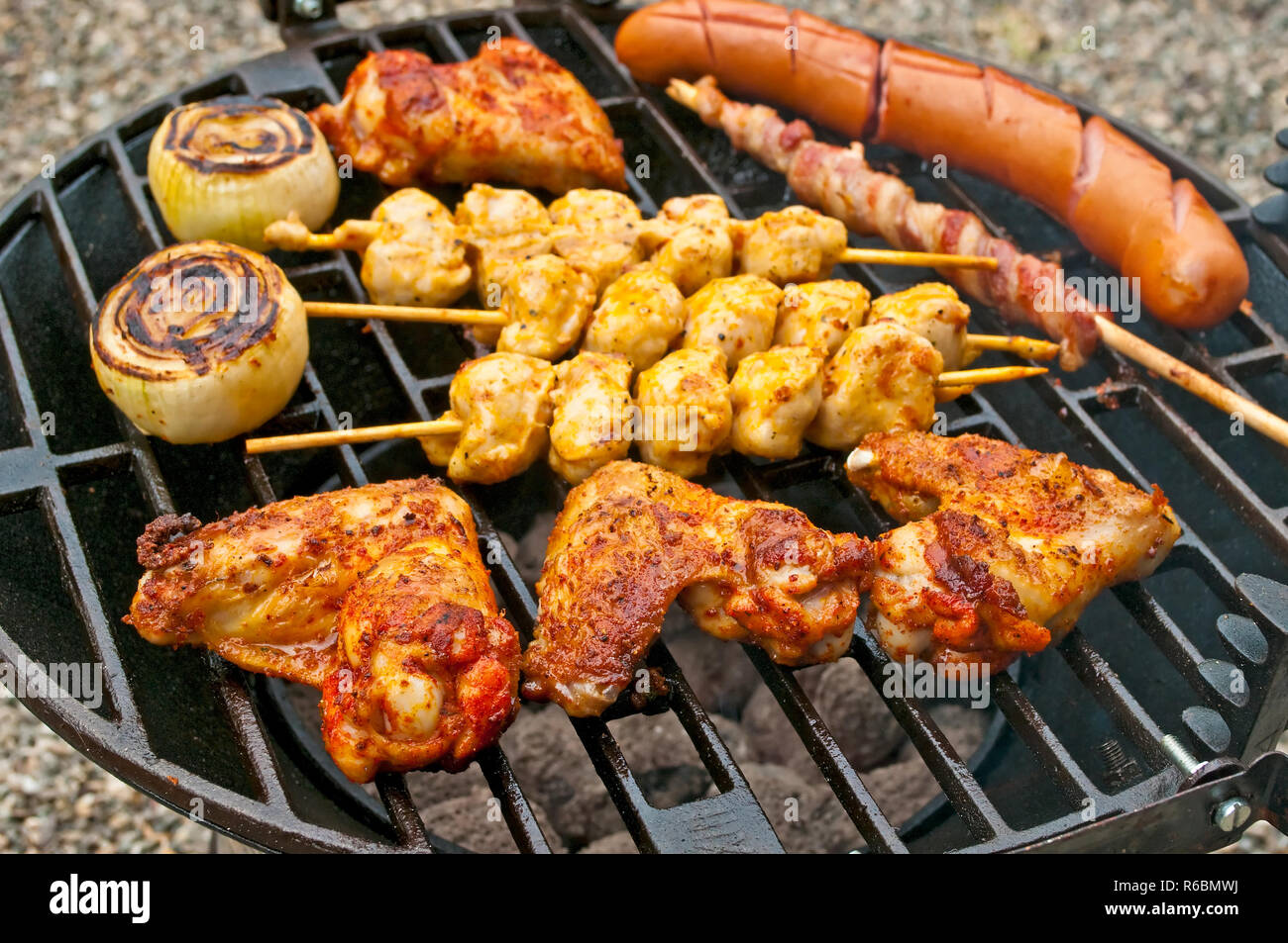 Barbecue mit Chicken Wings, Bratwurst, Fleischspieße und Schinken ...