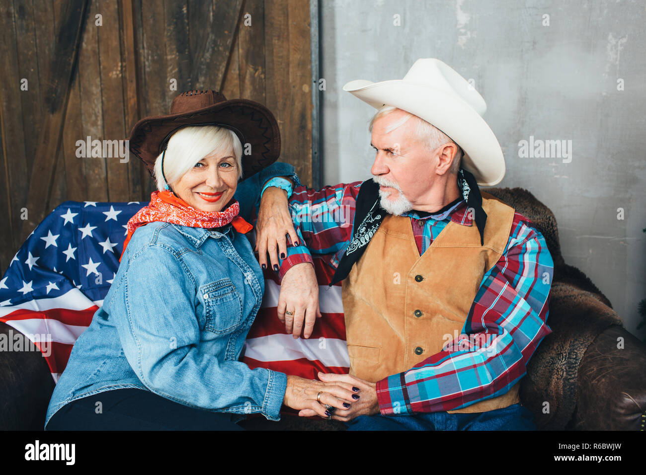 Amerikanische senior Paar tragen stilvolle Cowboyhut schöne Umarmung Stockfoto