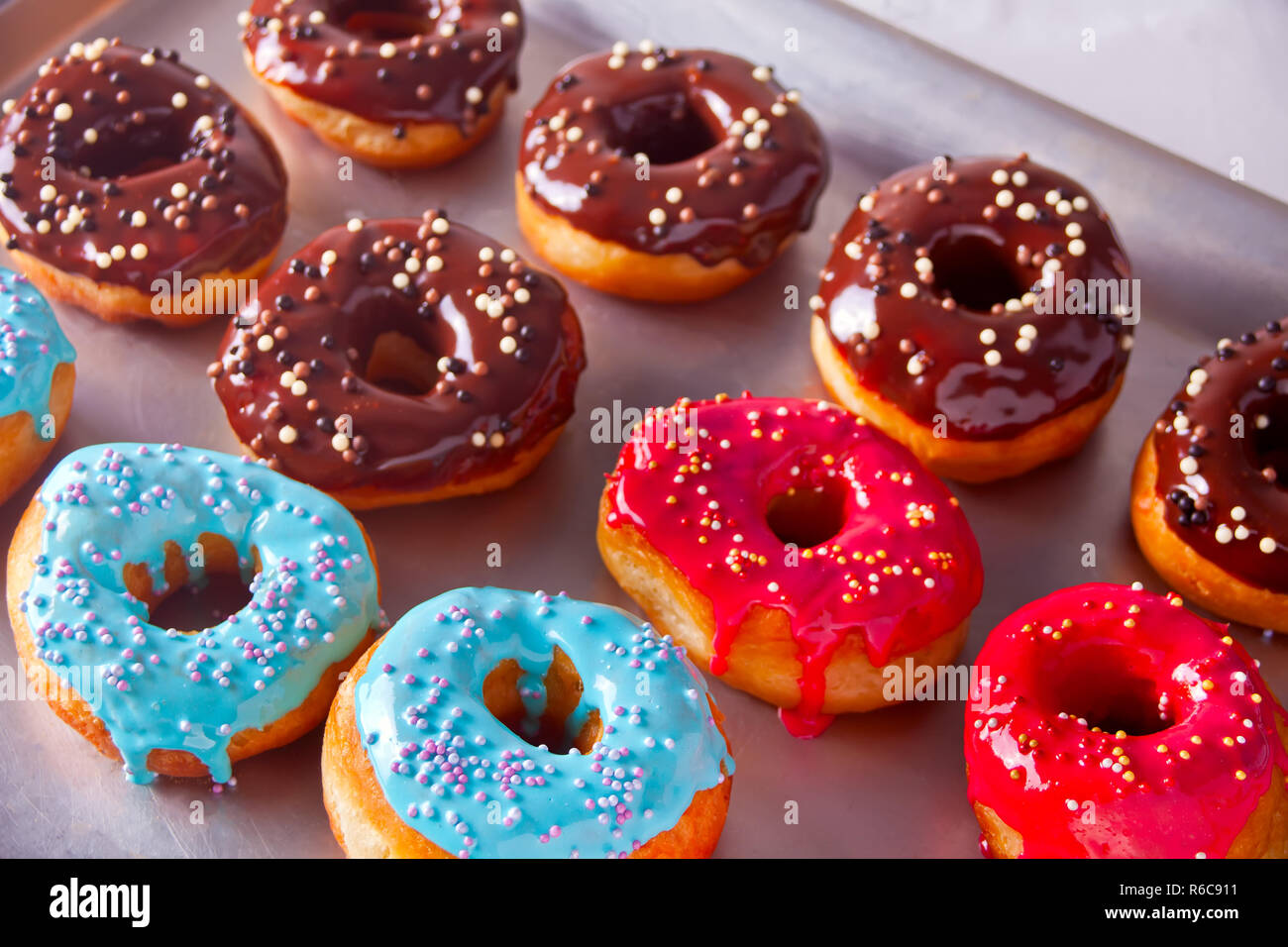 Frische bunte Rote. Braun und Blau Schokolade Donuts auf dem Backblech  Stockfotografie - Alamy