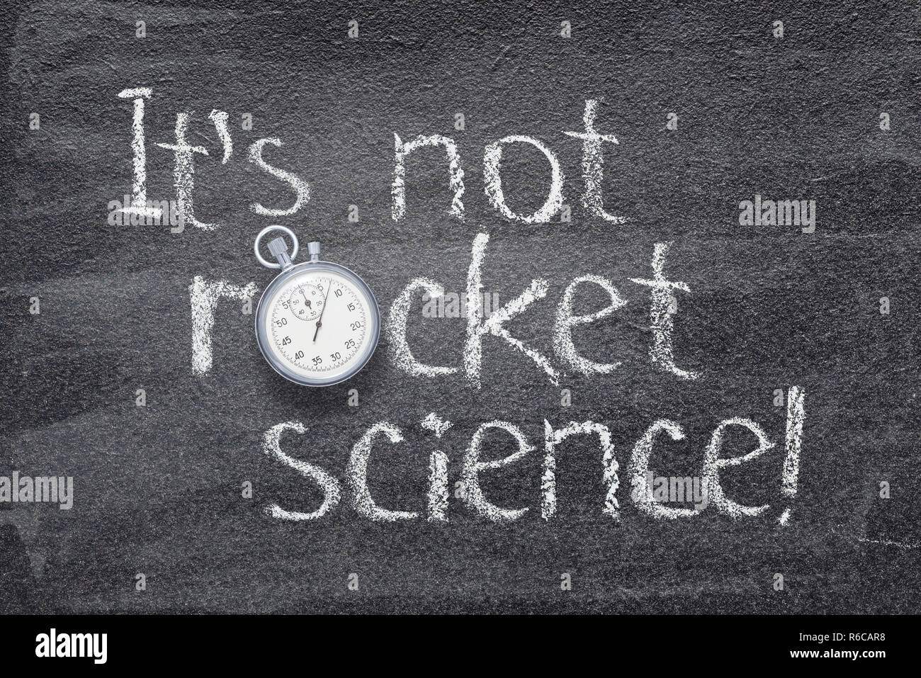 Es ist nicht Rakete Wissenschaft Ausrufezeichen auf Schiefertafel mit Vintage Stoppuhr statt O geschrieben Stockfoto