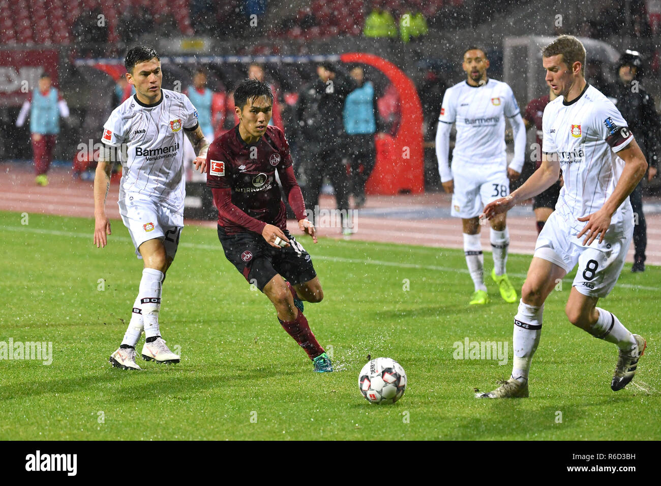 Nürnberg, Deutschland. 03 Dez, 2018. Yuya KUBO (1.FC Nürnberg, Mitte), Aktion, Duellen gegen Charles ARANGUIZ (Bayer Leverkusen, links) und Lars BENDER (Bayer Leverkusen). Fussball 1. 1. Fussballbundesliga, 13. Spieltag, Spieltag 13, 1.FC Nürnberg (N) - Bayer 04 Leverkusen (LEV) 1-1, am 03.12.2018 in Nürnberg/Deutschland. MAX MORLOCK Stadion. DFL BESTIMMUNGEN VERBIETEN DIE VERWENDUNG DER FOTOGRAFIE ALS BILD-SEQUENZEN UND/ODER QUASI-VIDEO. | Verwendung der weltweiten Kredit: dpa/Alamy leben Nachrichten Stockfoto