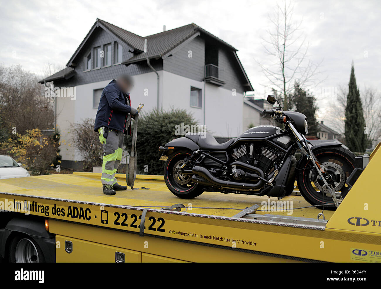 Pulheim, Deutschland. 05 Dez, 2018. Mitarbeiter von einem Abschleppdienst  laden ein Motorrad vor dem Haus ist ein Italienisches. Forscher in  Deutschland, Italien, den Niederlanden und Belgien haben eine Razzia der  italienischen Mafia