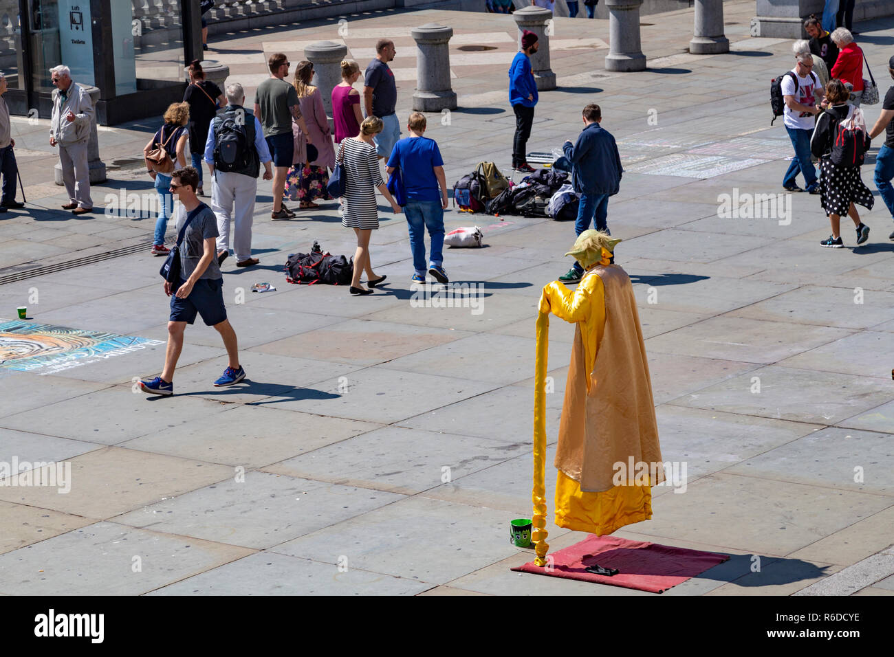 Street Performer gekleidet, wie Yoda. Der Schauspieler ist die Illusion, dass er schwebt. London, Vereinigtes Königreich Stockfoto