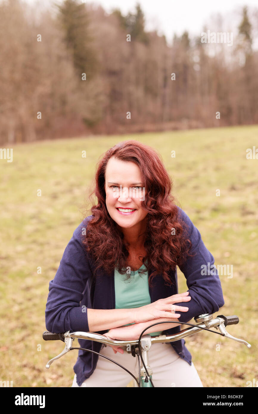 Porträt einer Frau Middle-Aged genießen die warmen Frühlingstage auf dem Fahrrad Stockfoto