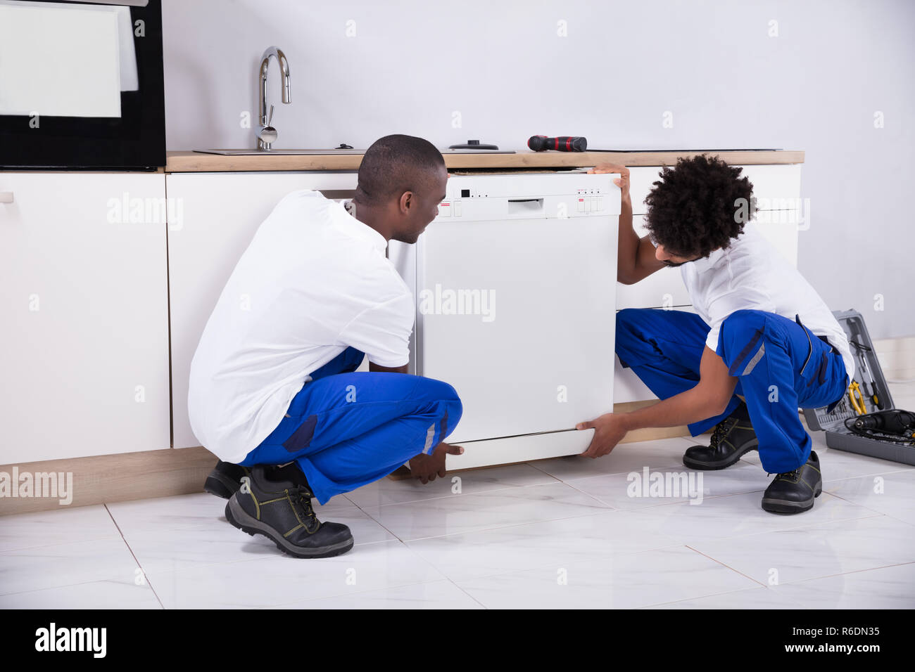 Zwei praktische Männer zur Festsetzung der Geschirrspüler in der Küche Stockfoto