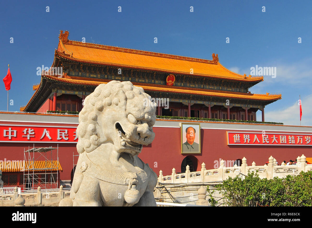 Ein Löwe Statue bewacht den Eingang zur Verbotenen Stadt mit Portrait von Mao Zedong im Hintergrund auf dem Platz des himmlischen Friedens Peking China Stockfoto