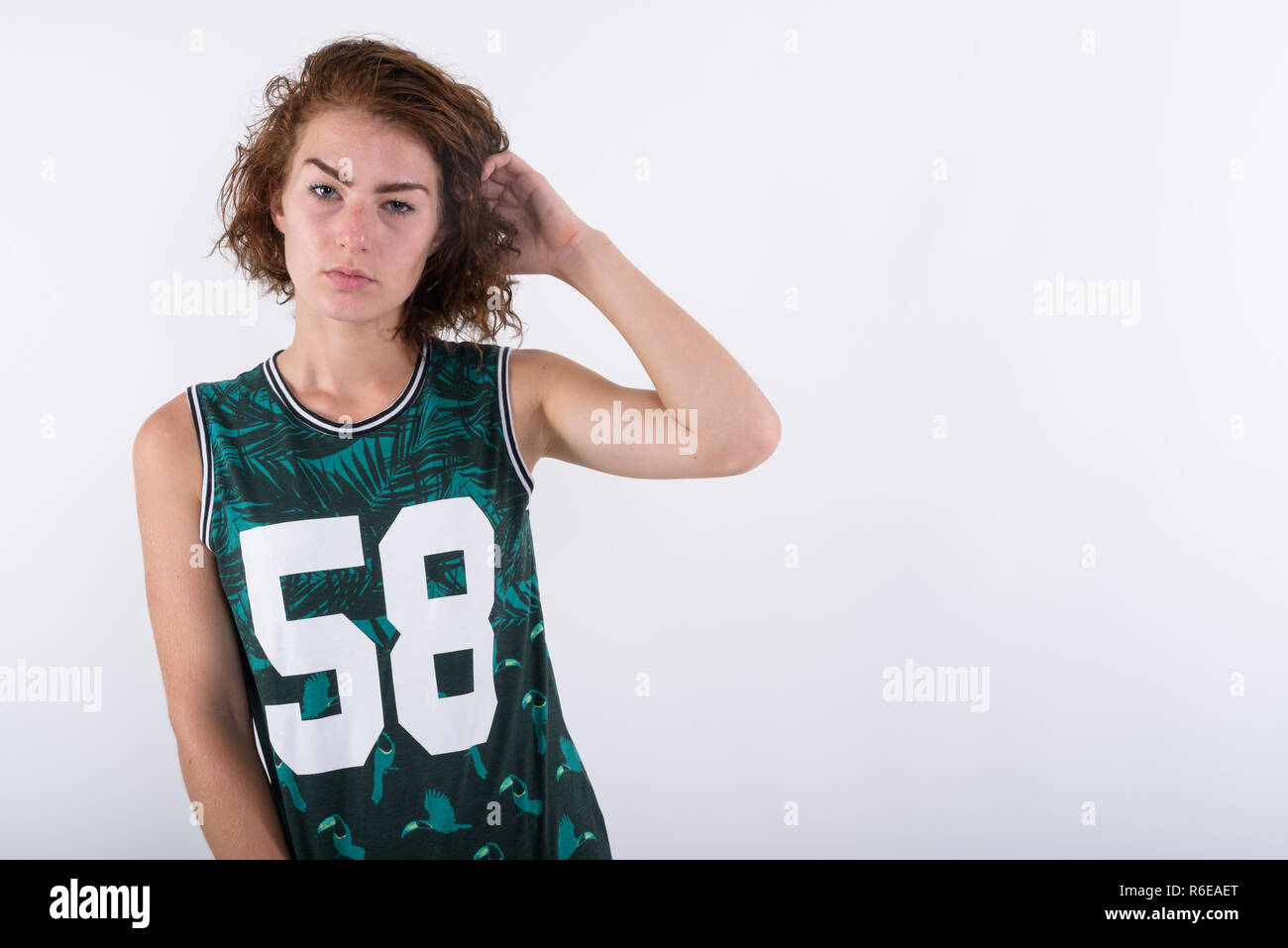 Studio shot von schönen Mädchen im Teenageralter zur Festsetzung ihr Haar gegen wh Stockfoto