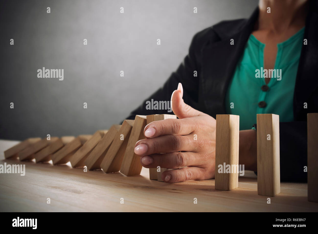 Geschäftsfrau hält eine Kette fallen wie Domino Spiel. Konzept zur Vermeidung der Krise und Ausfall im Geschäft Stockfoto